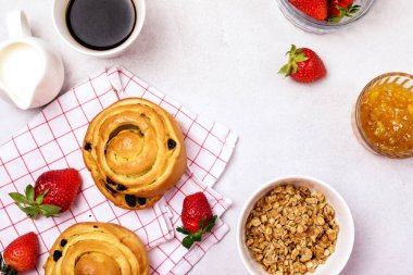 Lezzetli Kahvaltı Kuru Üzümlü Taze Çörekler ve Tarçınlı Kahve Fincanı Kremalı Çilek ve Portakal Reçeli Bardak Kasesi Üst Görüş Müsli