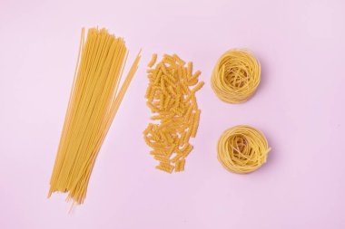 Kuru Makarna Makarnası 'nın Türleri ve Şekilleri Tagliatelle Fusilli Üst Görünüm Pembe Arkaplan