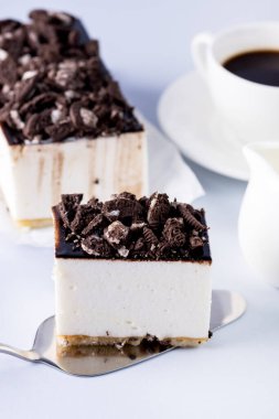 Lezzetli ev yapımı vanilyalı sufle ya da çikolatalı ve kurabiyeli kek. Siyah kahve, mavi arka plan. Tatil tatlısı.