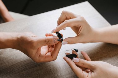 Modern minyatür işitme cihazları. Küçük ve ihtiyatlı görünmez işitme cihazları. Hasta ve doktora yakın çekim. Rehabilitasyon kliniği