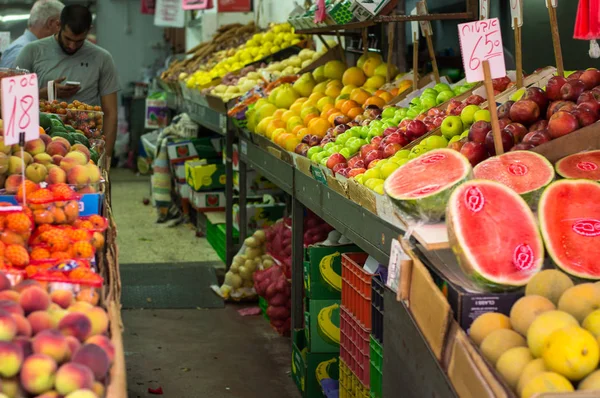 A friss ízű színes lédús gyümölcsök az istállóban, Carmel piac, Tel Aviv, Izrael. — Stock Fotó