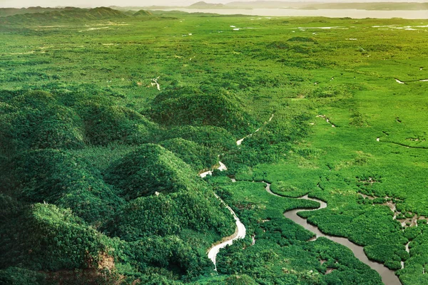 Vista aérea de la hermosa puesta de sol sobre las montañas y el bosque tropical de manglares verdes en la isla de Siargao, Filipinas . — Foto de Stock