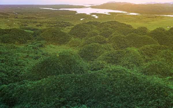 Vista aérea de la hermosa puesta de sol sobre las montañas y el bosque tropical de manglares verdes en la isla de Siargao, Filipinas . —  Fotos de Stock