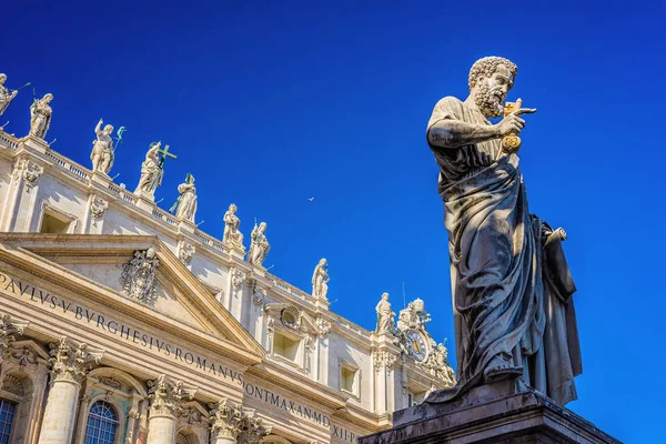 Statua di San Pietro in Piazza San Pietro, Città del Vaticano, con la facciata della famosa Basilica . — Foto Stock