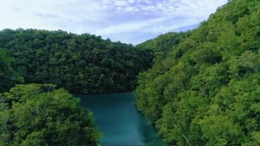 Siargao adasında bulutlar ile lagün tropikal manzara yağmur ormanları tepeler ve masmavi su, Filipinler. Drone Havadan görünüm 4kl