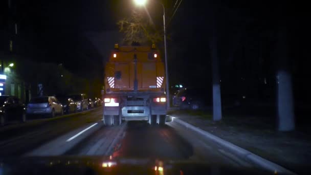 O aspirador de pó do carro vai para a frente e limpa a rua à noite na frente da câmera . — Vídeo de Stock