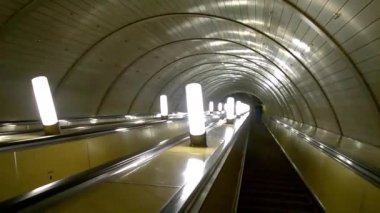 Metroda yürüyen merdiven aşağı gidiş bir sırt çantası olan adam. Döngüsü. Döngü