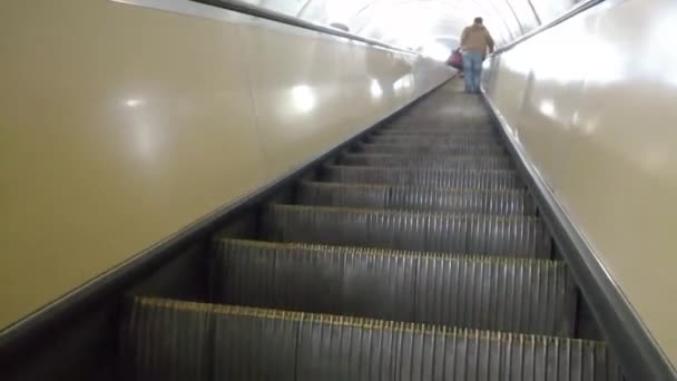 Un hombre está escalando una escalera mecánica en el metro — Vídeo de stock