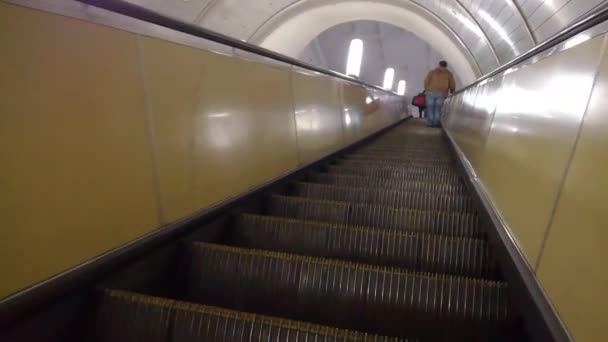 Мужчина поднимается на эскалаторе к выходу на Белорусскую станцию метро — стоковое видео