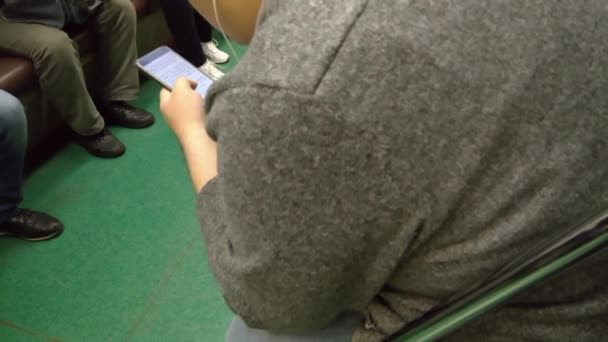 Hombre gordo leyendo el teléfono en el vagón del metro — Vídeo de stock