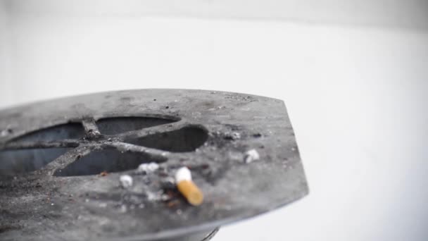 Zblízka se na ulici položí cigareta na kraji popelníku a hodí ji do urna — Stock video