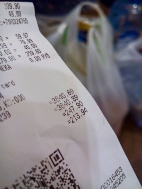 MOSCOW, RUSSIA - 14 Mart 2020: Plastik alışveriş torbalarının arka planında bir mağazadan alınan nakit makbuzu yakın plan