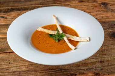 Grisini rustik ahşap zemin üzerine iki sopa ile sebze kabak ve havuç çorbası