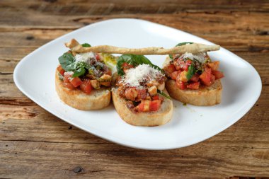 Bruschetta taze domates, parmesan ve fesleğen ahşap arka plan üzerinde