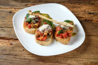Bruschetta taze domates, parmesan ve fesleğen ahşap arka plan üzerinde