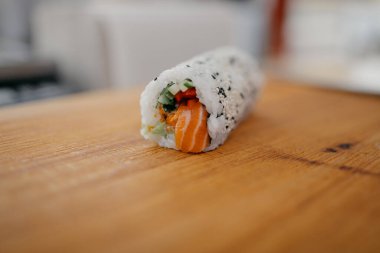 Tahta kesme tahtasında suşi rulosu, yakın görüş. 