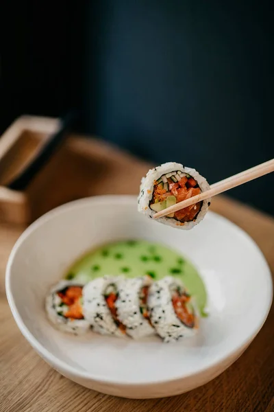 Honhand Håller Träätpinnar Med Sushi Över Plattan Närvy Stockbild