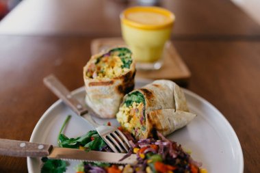 Sebzeli sandviç, tabakta salata ve bir bardak kahveyle kapat.