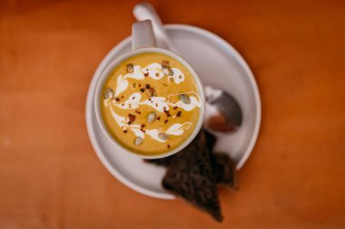 Latte ve ekmek dilimli fincanlar, bulanık arka planda kaşıkla. 