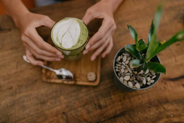 Mains Féminines Tenant Tasse Avec Latte Matcha Sur Table Bois — Photo