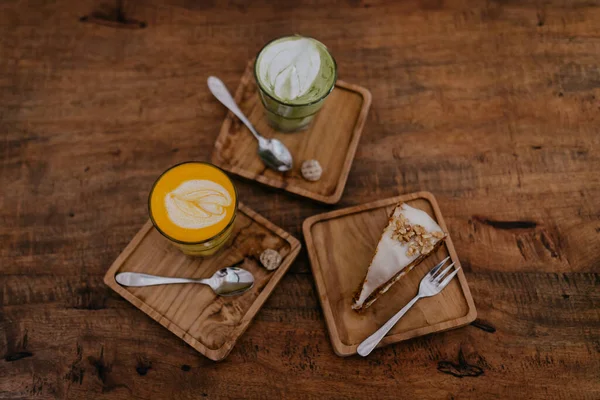 木製のテーブルの上に甘いケーキとコーヒーのグラスと木製のプレート 近いビュー — ストック写真