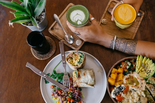 Kvinna Sätta Glas Kaffe Nära Tallrikar Med Frukost Bordet Närbild — Stockfoto