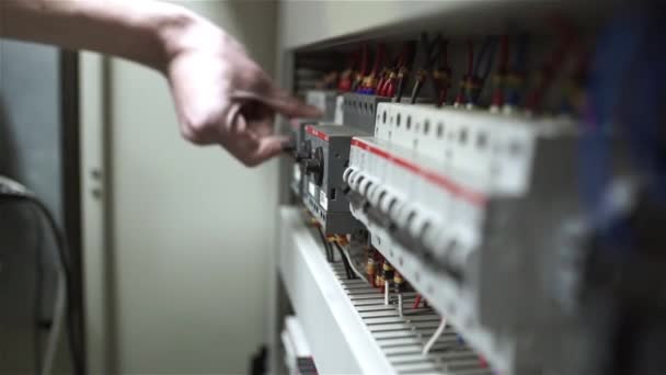 De elektricien schakelt op de stroomonderbrekers en start het systeem — Stockvideo