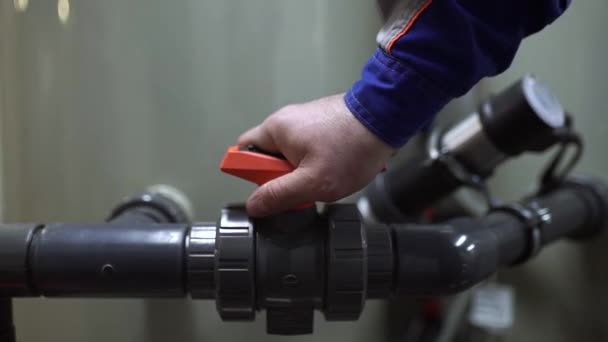 De werknemer sluit de klep op de buis en stopt de watertoevoer naar de tank — Stockvideo