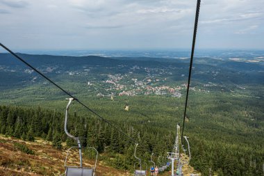 Szklarska Poreba, Polonya - 27 Ağustos 2025: Karkonosze Dağları Ulusal Parkı ağaçlarının tepesinde yaz mevsiminde turist ve yürüyüşçülerle dolu Szrenica tramvayı