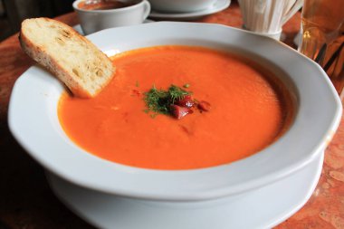 Balkabağı kreması. Sosisli çorba ve beyaz tabakta beyaz ekmek.