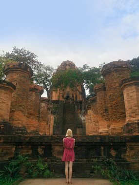 Sarışın kız Po Nagar 'a bakıyor. Süslü elbiseli bir kızın arkadan görünüşü.