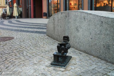 Wroclaw, POLAND - 24 Ağustos 2018: Wroclaw 'da bir bilgisayarda çalışan bir cücenin anıtı. Wroclaw sokaklarındaki küçük figürler, cüceler büyük bir turistik ilgi odağı. Polonya.