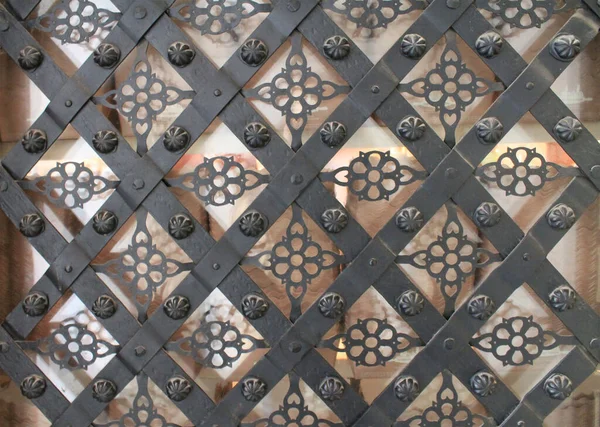 Dekoratif metal kapı süsü. Klasik süslemeli antika demir kapı. Süslemeli geometrik desen ve soyut renkli arkaplan.