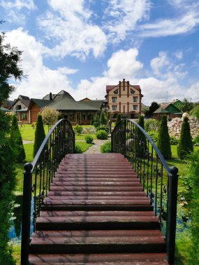 Yeşil çimleri ve haydutları olan bir kır evine giden köprünün güzel manzarası.