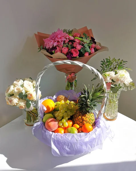 Komposisi Meja Putih Meriah Dengan Karangan Bunga Dan Sekeranjang Buah — Stok Foto