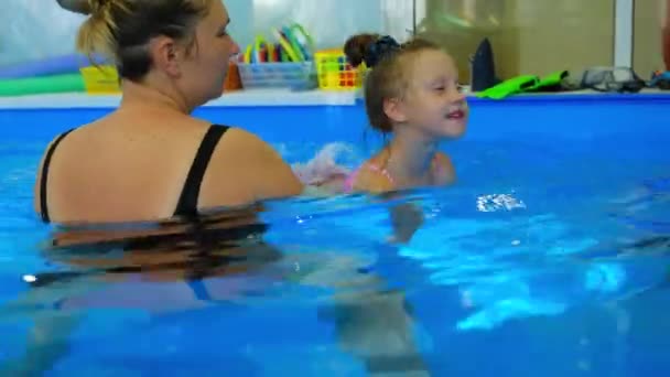 Девушка 5-6 лет тренируется в бассейне. — стоковое видео