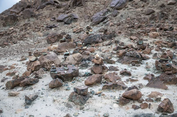 Hindistan 'ın uzak Himalaya çöllerinde düzgünce istiflenmiş taş cairns. Geleneksel kabileler, engebeli dağ manzaralarına karşı oluşturulan rehberliği, meditasyonu ve maneviyatı sembolize eder. Seyahat, kültür, doğa ve farkındalık temaları için mükemmel..