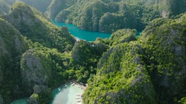 Canlı turkuaz sular çevredeki dağların yemyeşil yeşiliyle tezat oluşturur. Kayangan Gölü. Coron, Palawan, Filipinler.