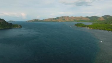 Yuvarlanan tepeler ve dağ vadileriyle çevrili engin bir okyanus. Coron, Palawan, Filipinler.