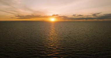 Altın renklerin havadan görünüşü, güneş ufukta batarken sakin açık okyanusu yansıtır. Koh Tao, Tayland.