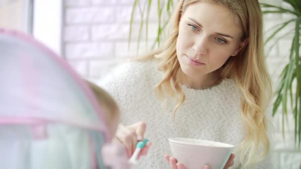 Gyönyörű nő eteti a babát. Yong anyai gondoskodás gyermek — Stock videók