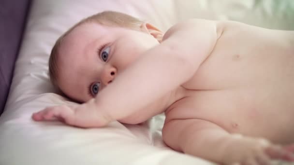 Bebé desnudo acostado en la cama. Dulce entorno de aprendizaje infantil — Vídeos de Stock