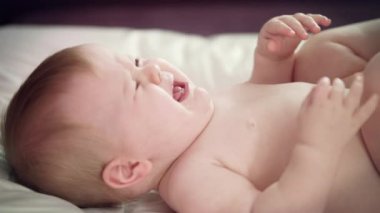 Bebek bezi takmak istemediği için ağlıyor. Üzgün bebek ağlıyor.