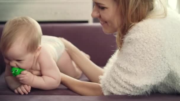 Feliz madre sosteniendo al bebé a la mano. Madre aprendiendo bebé arrastrándose — Vídeo de stock