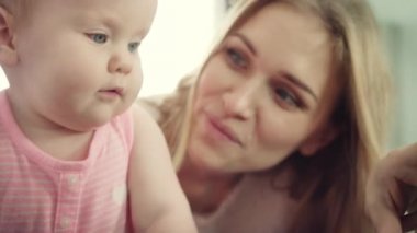 Bebeği olan mutlu bir anne. Gülümseyen kadın çocuğunu kucaklıyor.
