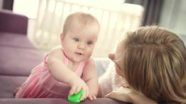 Güzel bebek annesiyle oynuyor. Küçük çocuk evde oyuncak oynuyor.