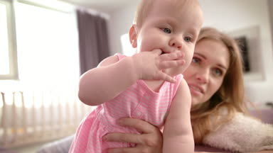 Anne kucağında bebeği tutmaktan yoruldu. Çocuk eğitimi ayakta duruyor. Annesiyle güzel çocuk.
