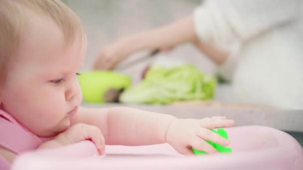 Mamma sta cucinando per il bambino. Mamma che taglia insalata verde. Donna cucina cibo sano — Video Stock