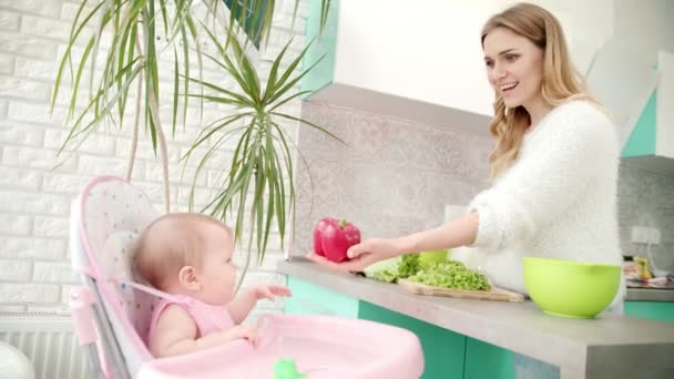 Mutter mit Baby in der Küche. Gesunde Babynahrung. Frau kocht Gemüse — Stockvideo