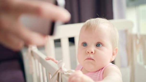 Adorable bebé viendo el teléfono móvil. Niño atento ver en el teléfono inteligente — Vídeos de Stock